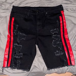 Black ripped shorts with red stripes on the sides